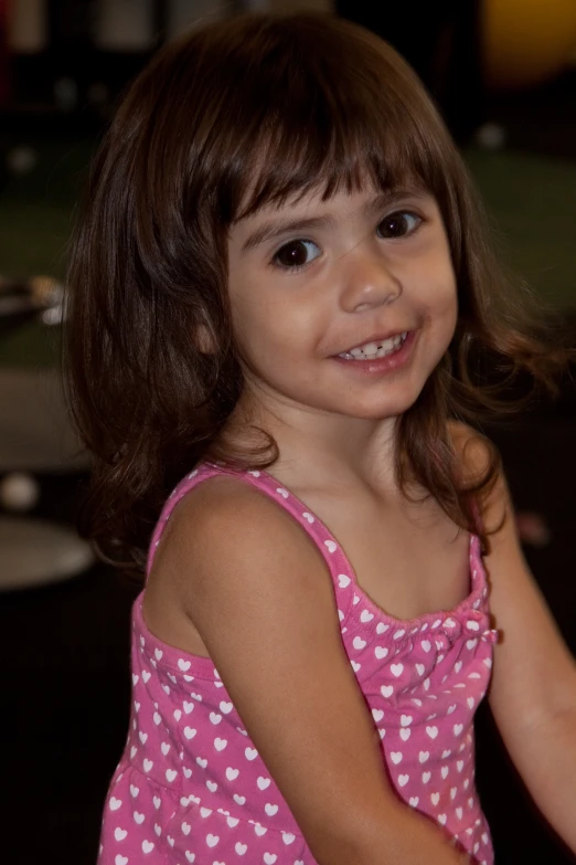 the girl smiles at the camera while she holds a piece of cake