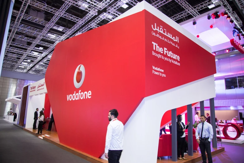 a man looking at the company logo on a red booth