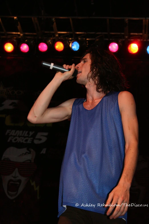 a man holding a microphone on stage at night