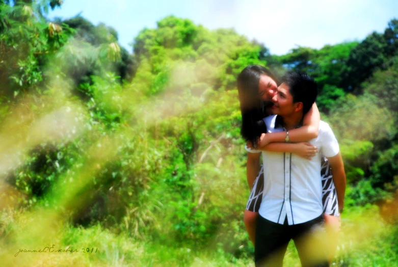 a man hugs his wife in the outdoors