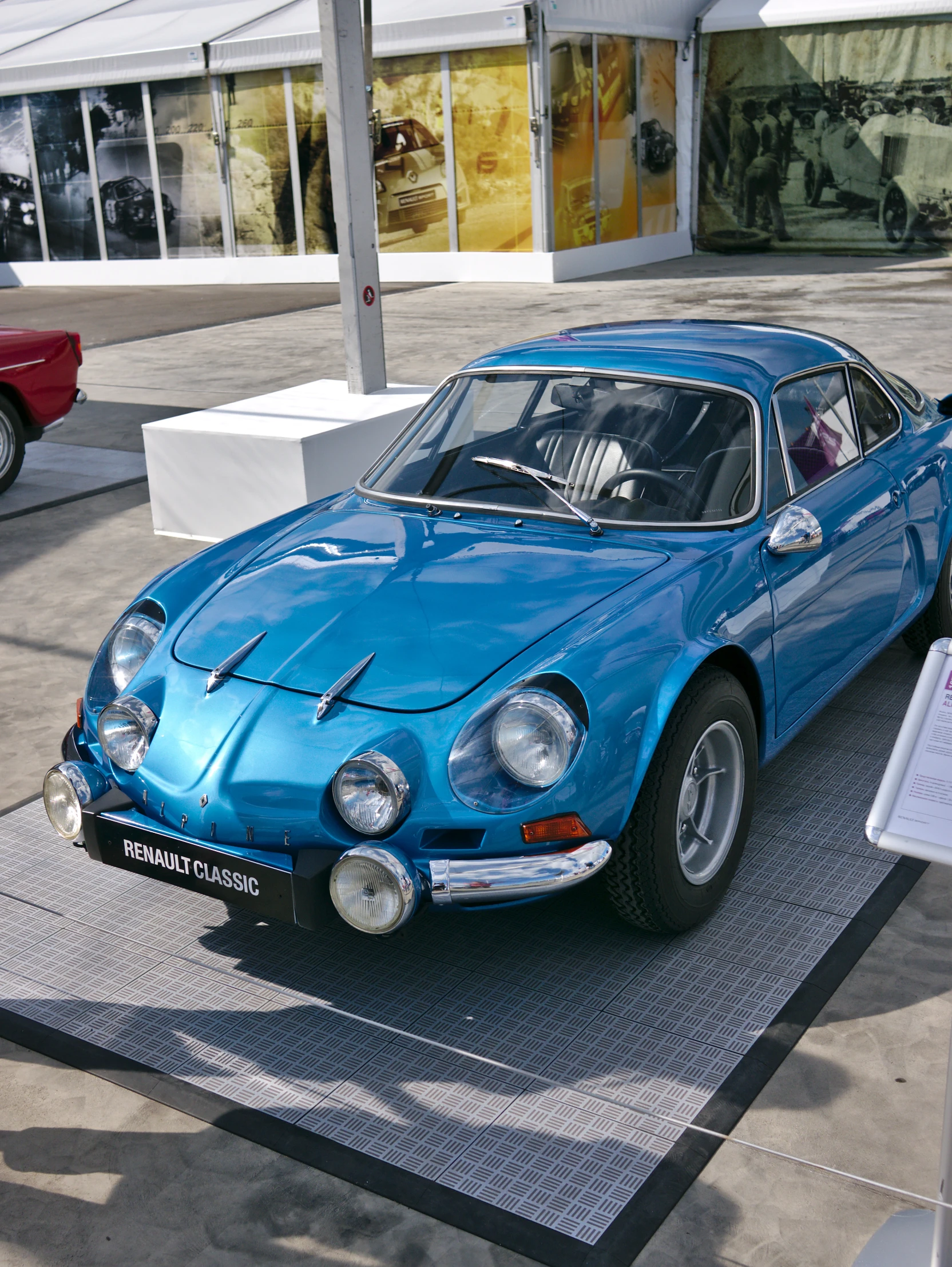 a blue car is on display in a museum