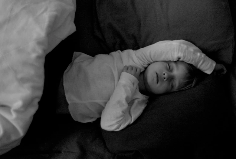 a small child laying on top of a bed