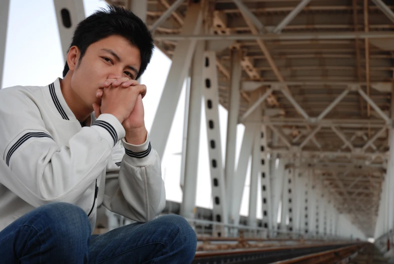 a man in white jacket holding his hand near his mouth