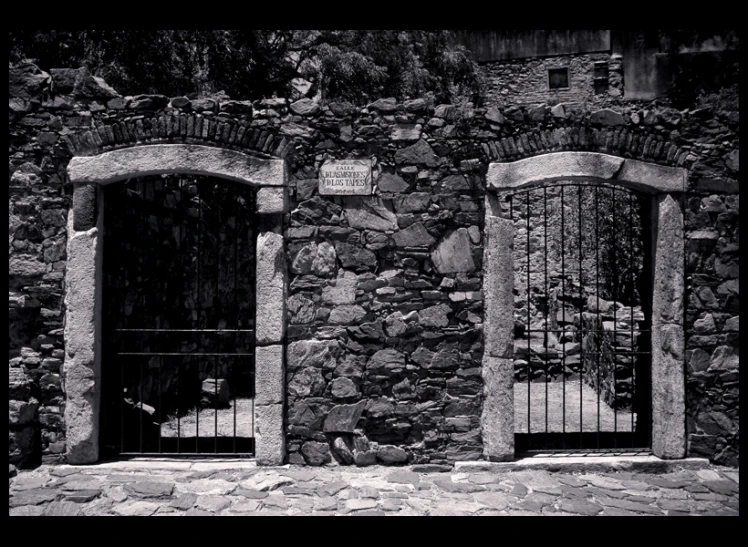 an old stone house with two open windows