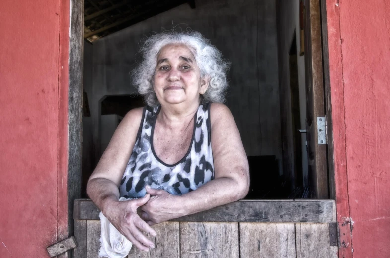 a woman sitting down by a window and looking outside