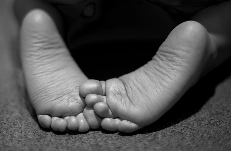 the lower part of a person's foot while resting on their bed