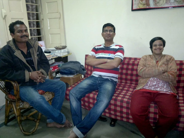 three people sitting on red and white couches