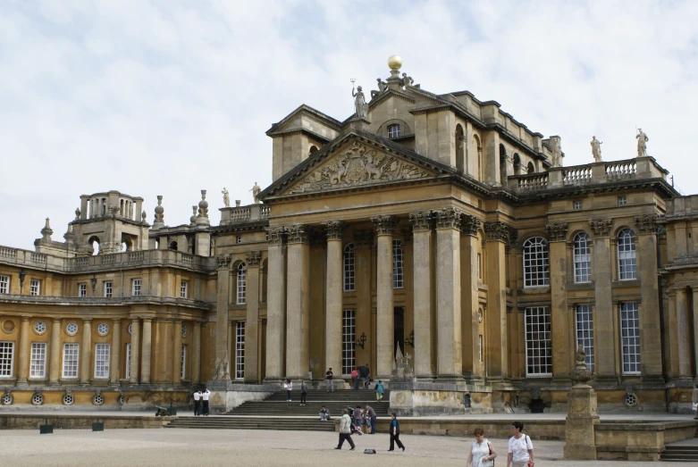 several people walking by large buildings with many stairs