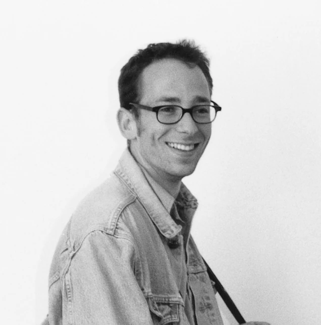 a man holding a baseball bat while wearing glasses