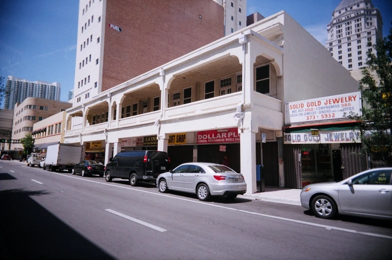 several cars are parked outside a multistory building in the city