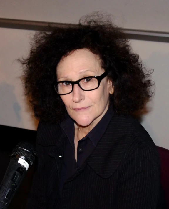 an image of a woman with a black jacket and glasses