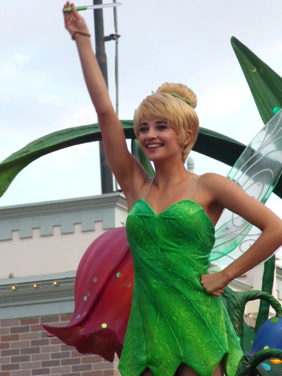 the woman dressed as a leaf fairy poses with a kite