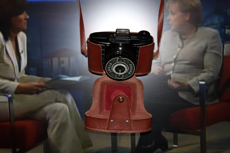 an old fashioned camera on display with another person in background