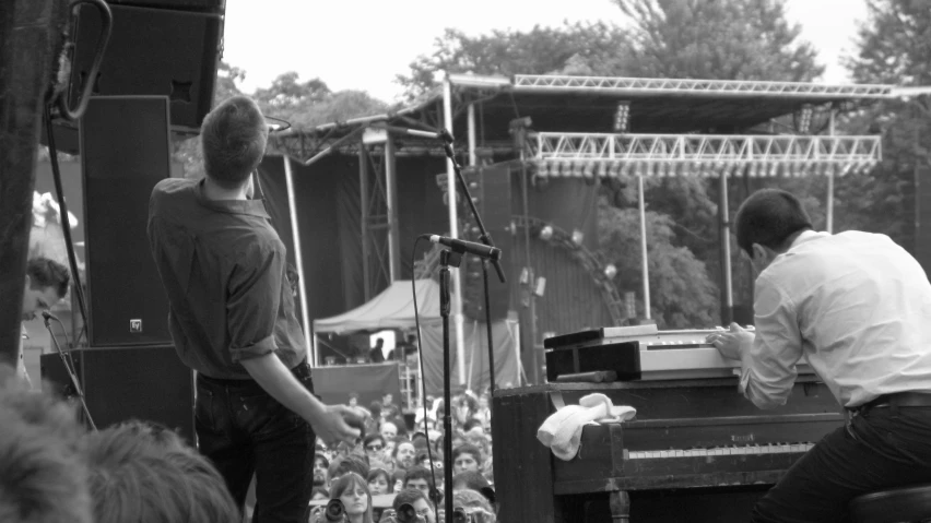 a man with a piano at an outdoor concert