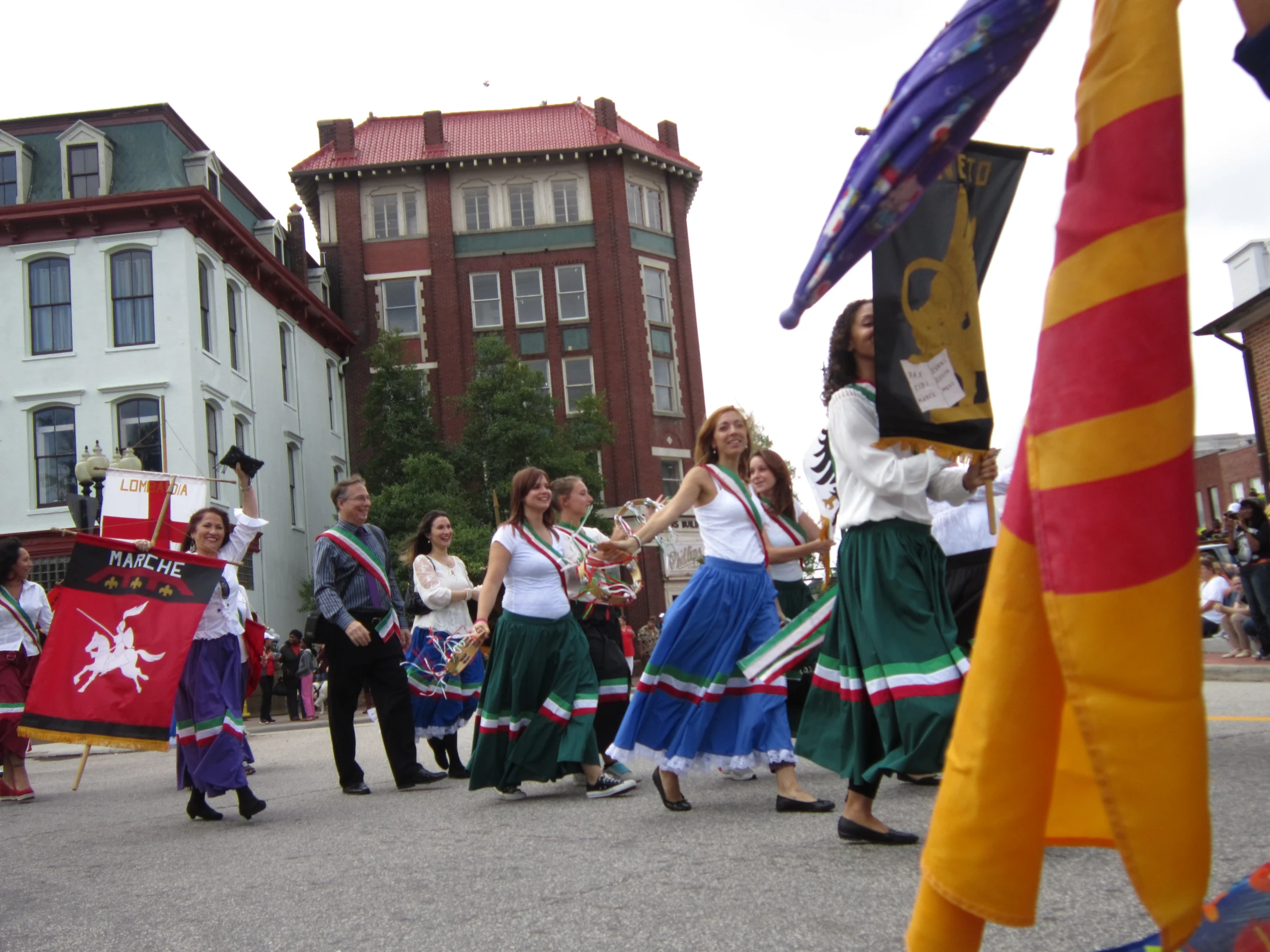 a group of people in colorful outfits dancing in front of a building