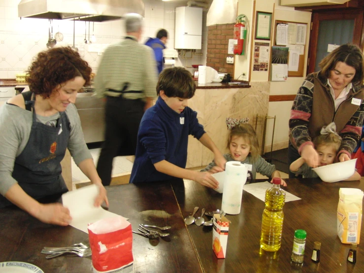 a mother and three children prepare lunch at the dining table