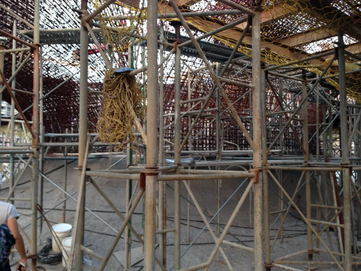 men working on a bamboo cage inside an industrial facility