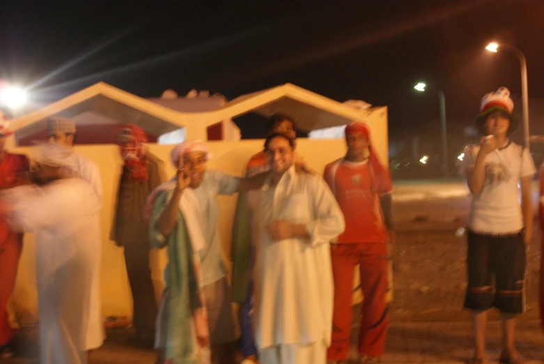 people in costumes stand in front of a house at night