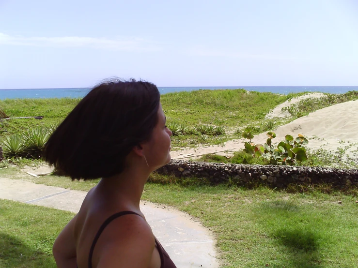 a woman standing in the grass with a bird in the air