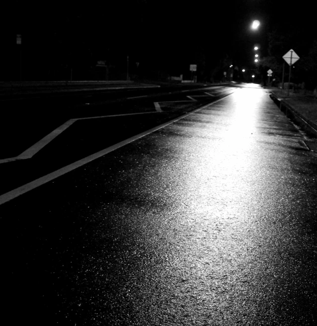 black and white street scene of a single light at night