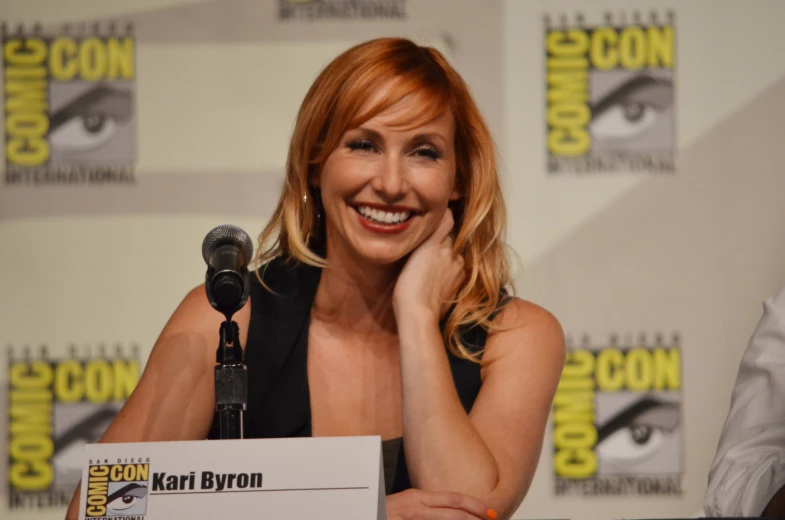 a smiling woman at a convention in a black dress