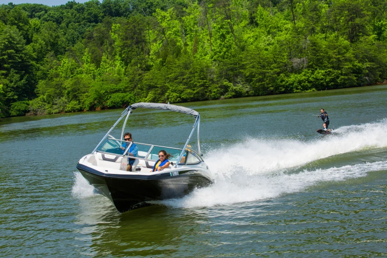 three people on water skis being towed by boat