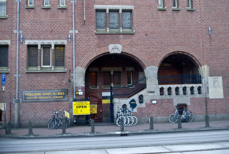 three bicycles locked up in front of a brick building