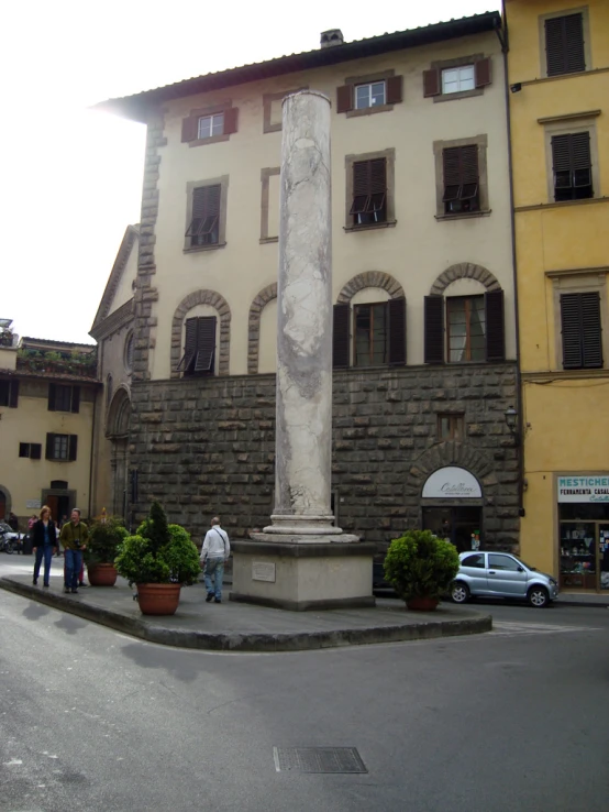 the tall statue is in front of the big building