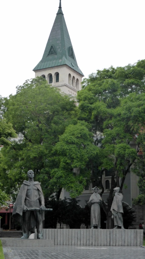 statue sitting on pedestal in front of a large building