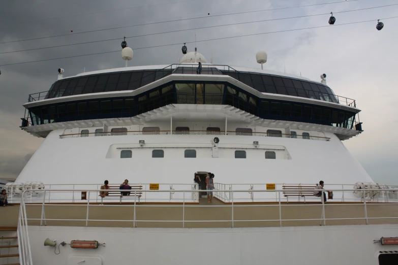 the deck of a cruise ship with people standing on a balcony