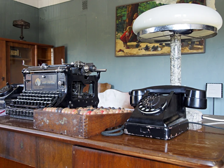 an old fashioned typewriter and a machine sit on the counter