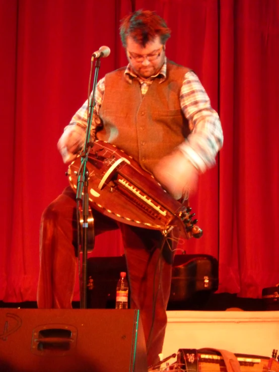 a man standing on stage while playing the lyraphone