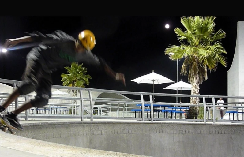 a skateboarder doing tricks on a wall at night