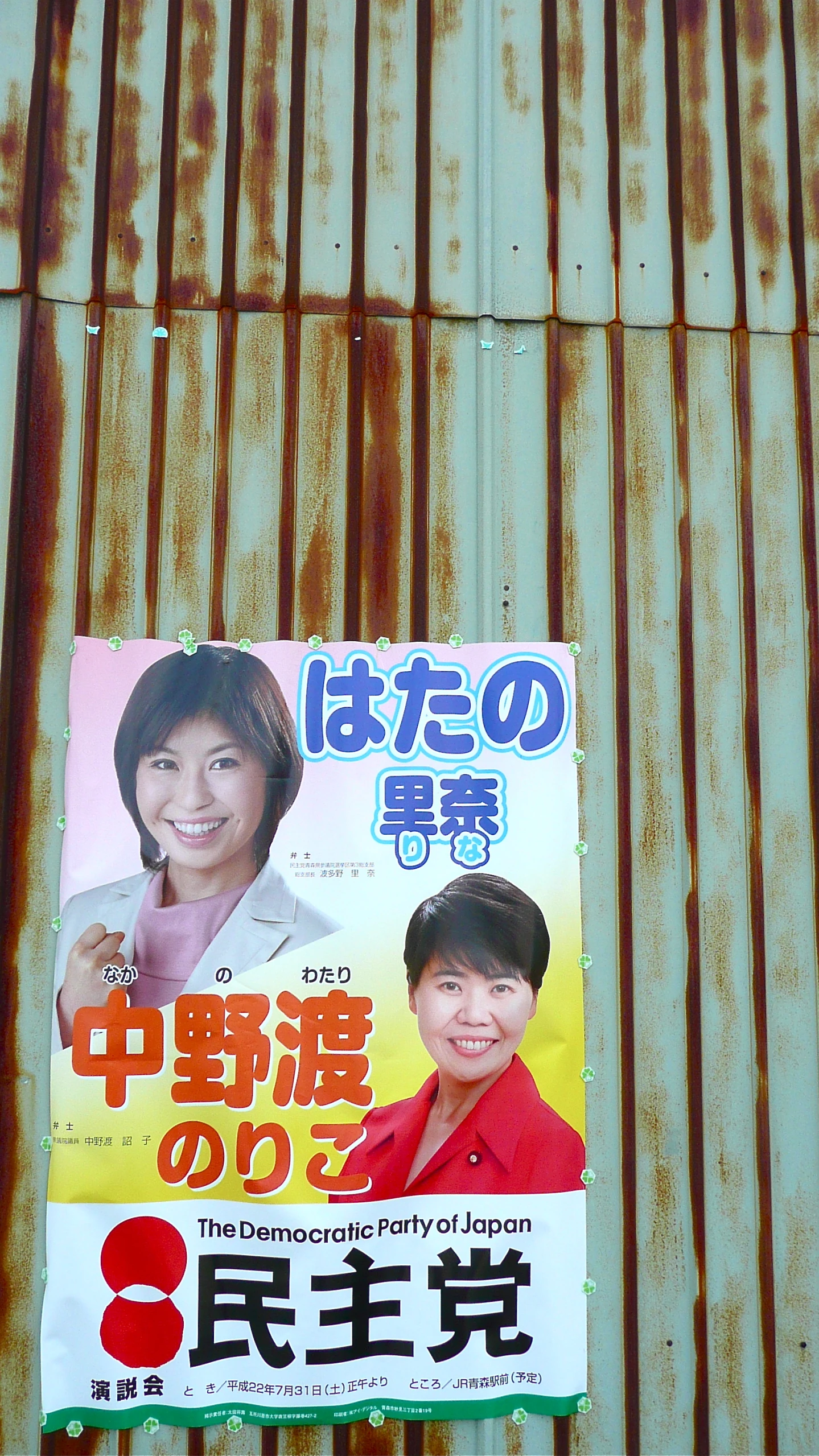 a poster hanging off of the side of a corrugated metal structure