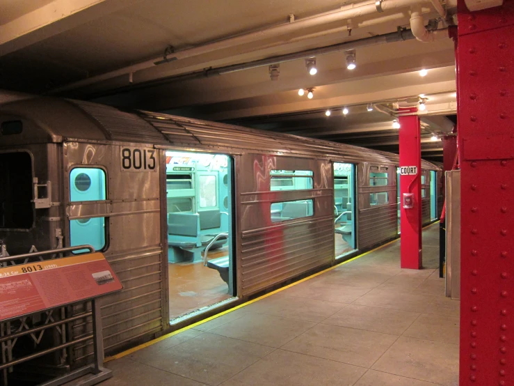 silver train in an underground station with no passengers