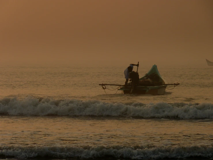 a man in a boat on the water near some waves