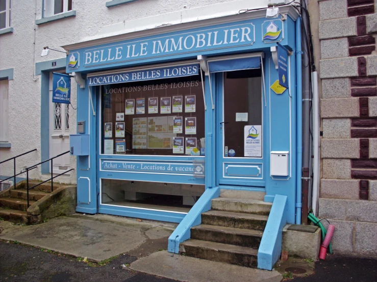 a small blue shop on the side of a building