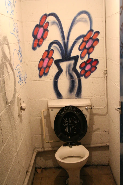 a restroom with white walls and graffiti on the walls