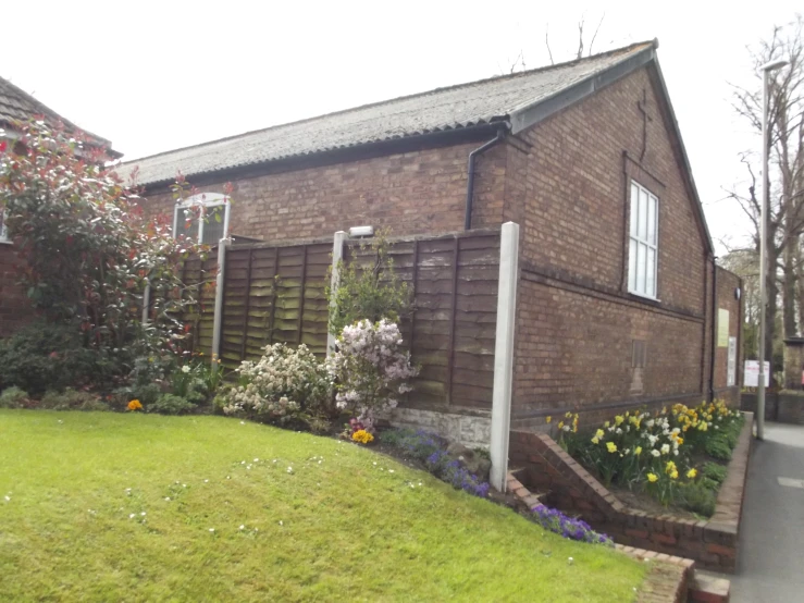 a home with flower garden and shrubbery around the edge