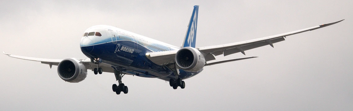 a blue and white jet plane flying in the sky