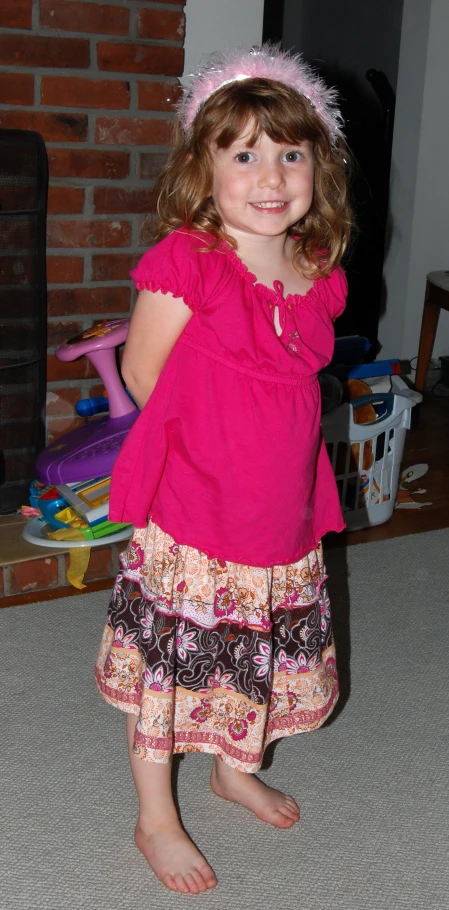 a  wearing a pink dress and headpiece