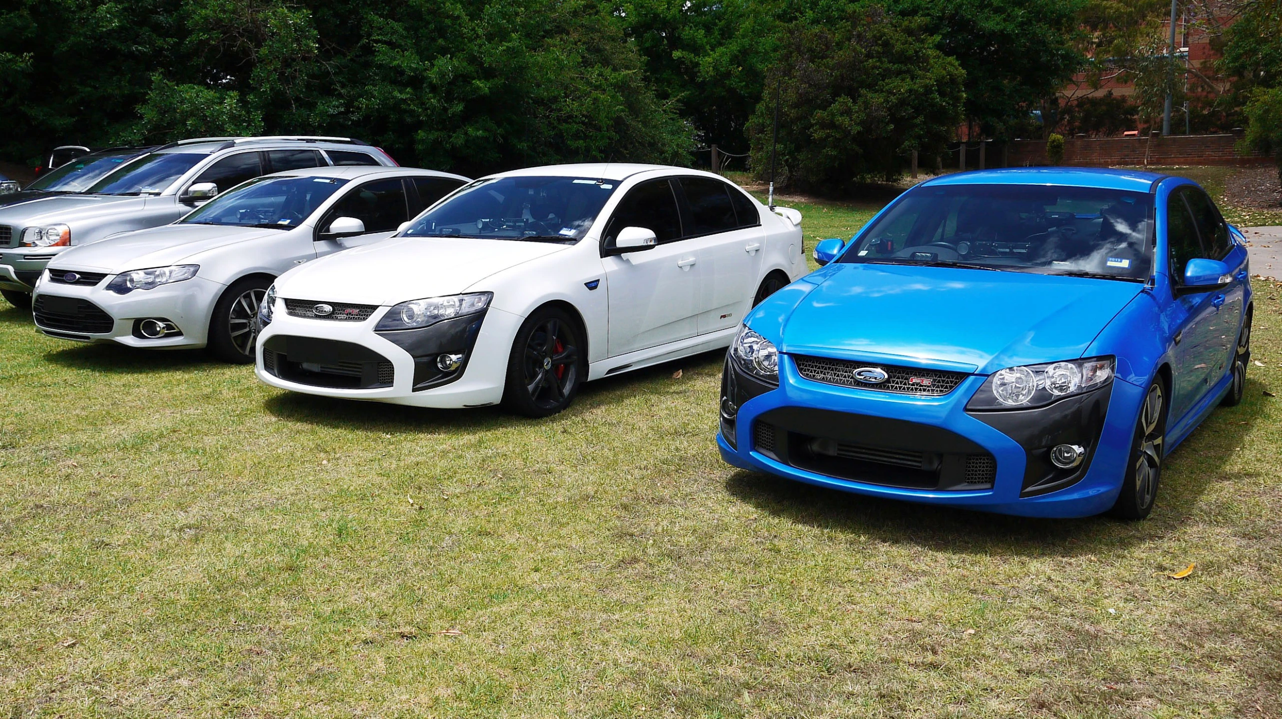 a row of cars sitting on top of a field