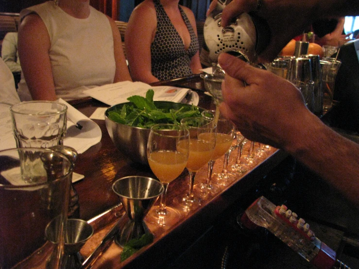 there is a bartender pouring alcohol into several glasses on a bar