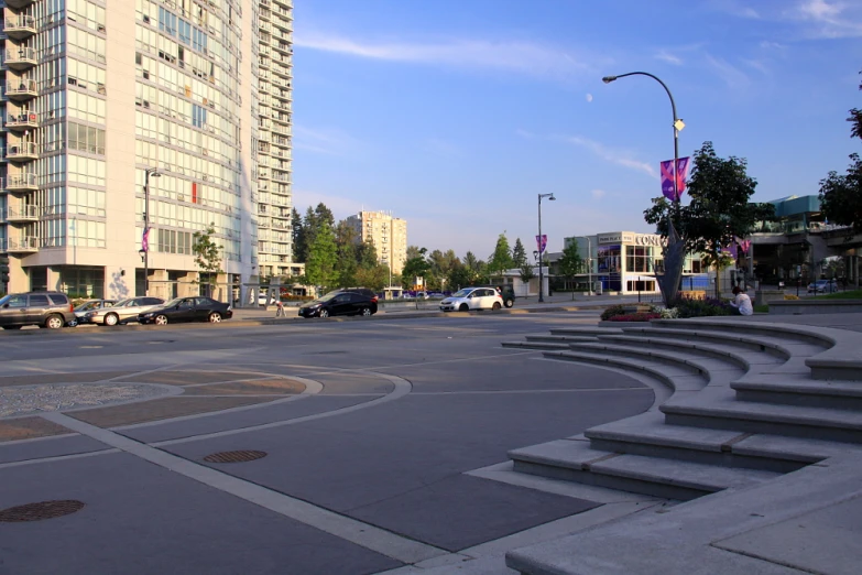 a road with steps and cars parked in the distance