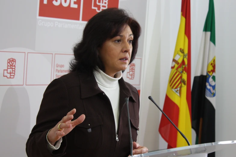 a woman standing at a podium with her hands out