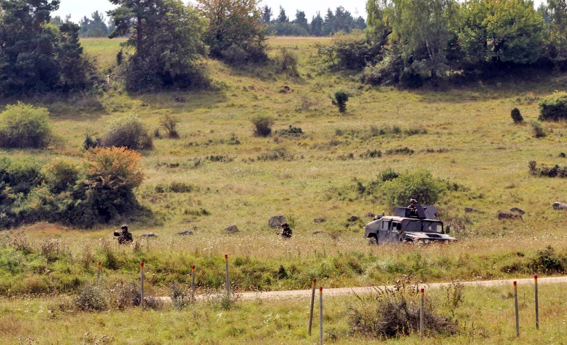 an old truck parked in a field on the side of a road