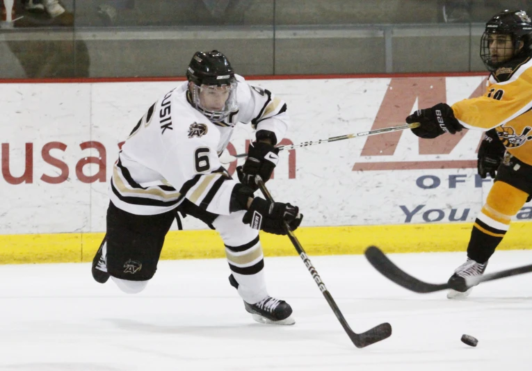 two hockey players during a game with an opposing player