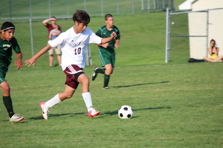 three young men playing soccer on a field