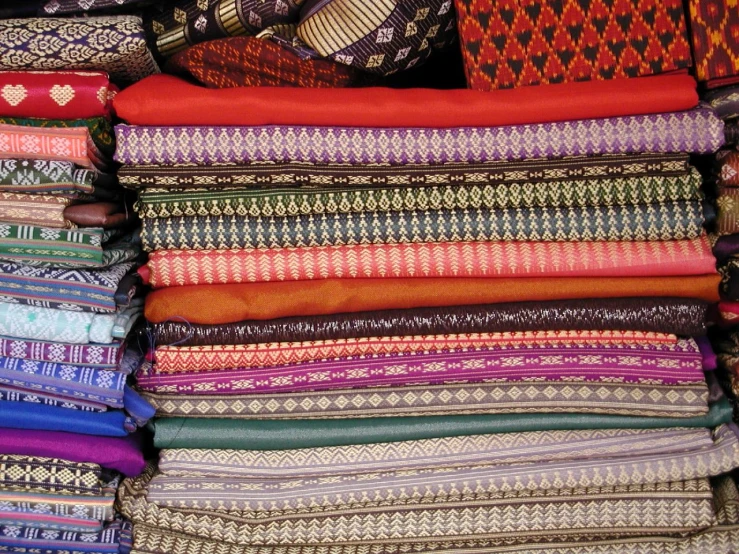 many bright colored fabrics sitting on top of each other