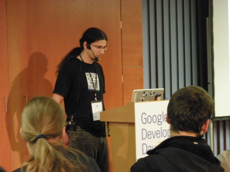 a man standing in front of a podium giving a lecture